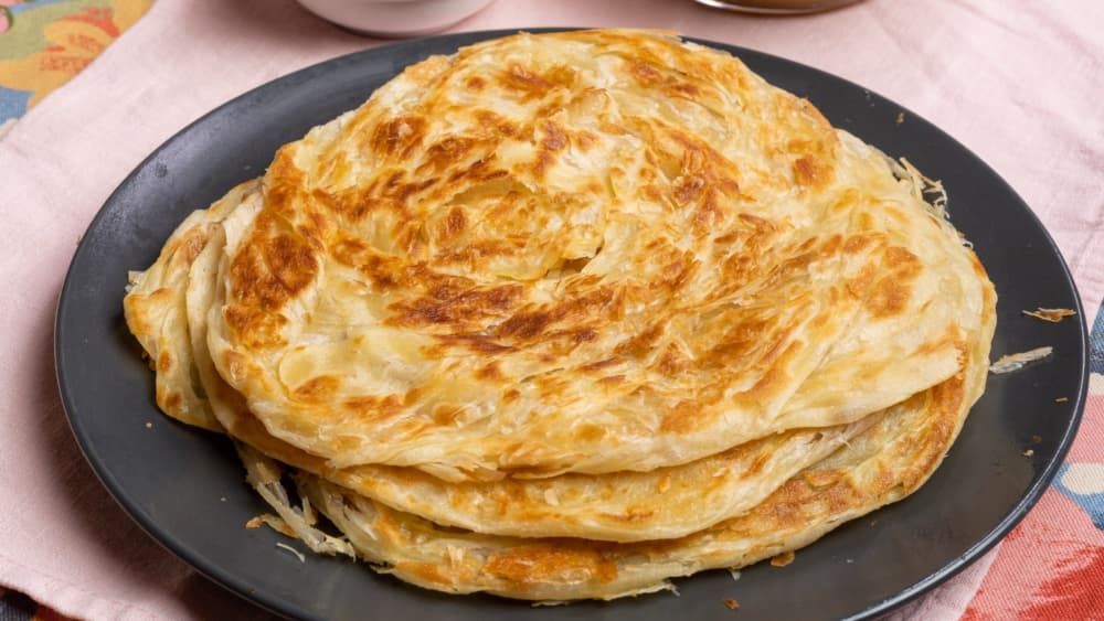 Roti canai lembut gebu dihidang bersama kari dalca tumis darat